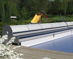 Instalación de un enrollador de lamas en piscina con vistas a un bosque