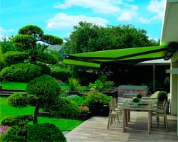 Toldo verde Ma6000 no jardim com mesa e cadeiras