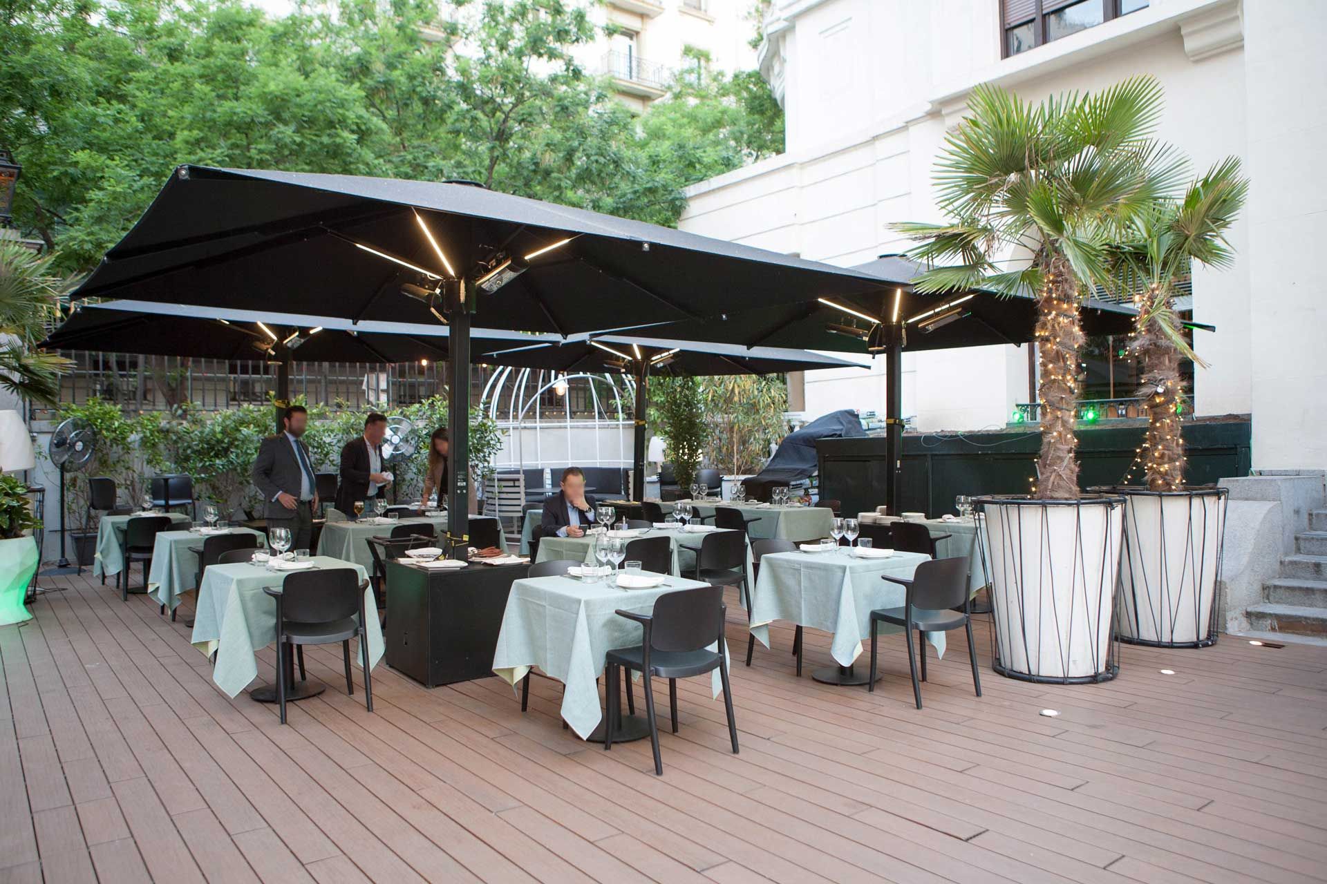 Four black Azores parasols on the terrace of a restaurant