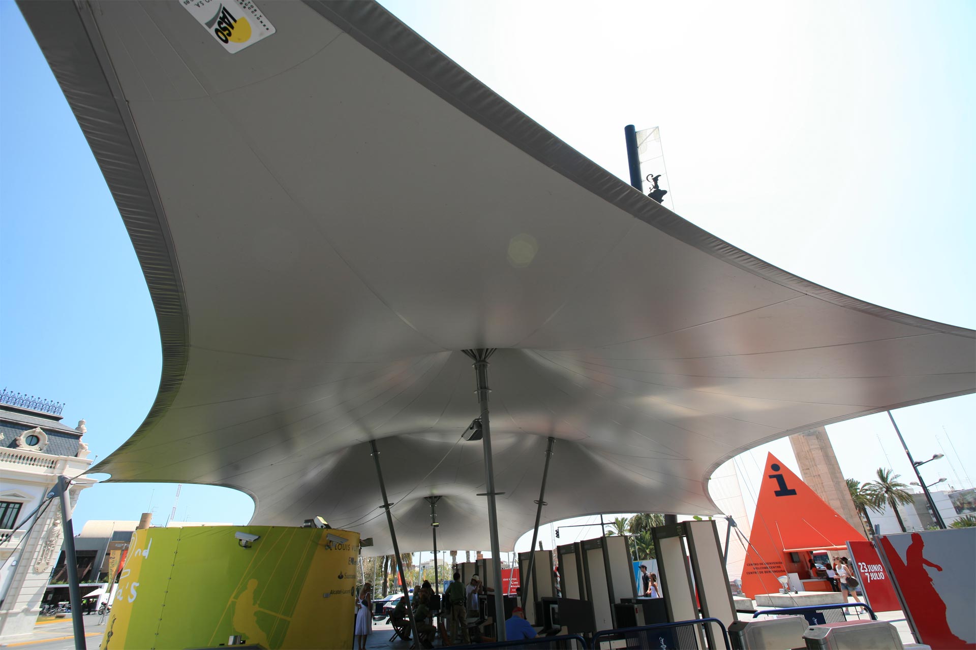Estructura tensada en forma de carpa de circo con lona gris cubriendo equipamientos
