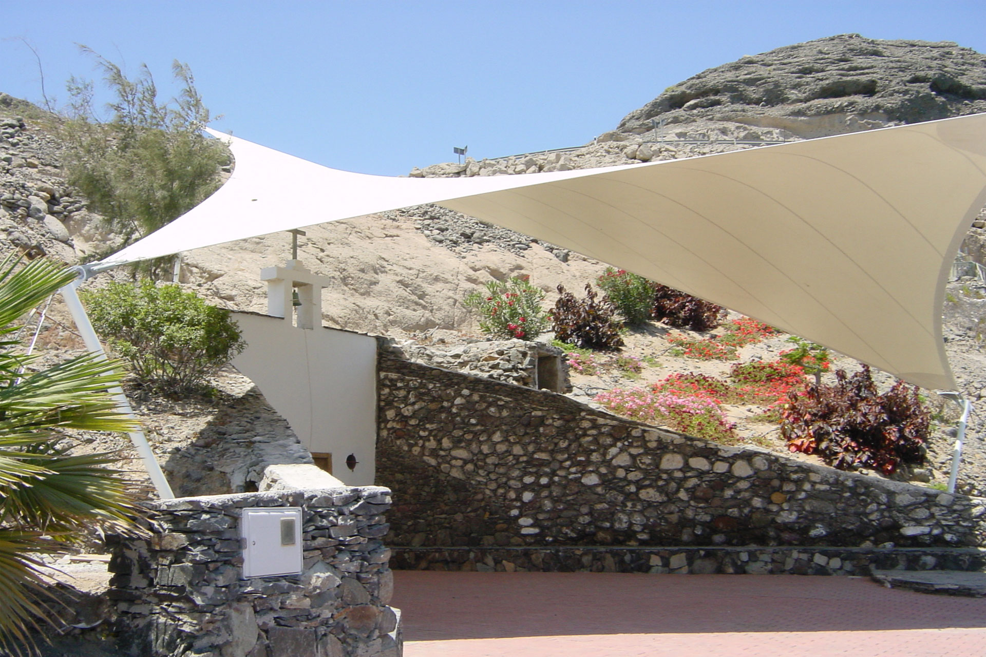 Estructura tensada en un turón cubriendo la ermita del pajar