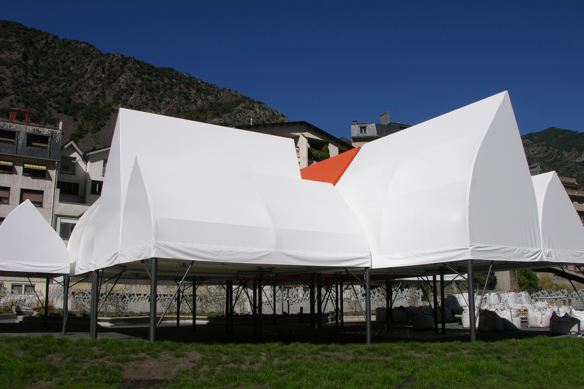 Estructura tensada en forma de tiendas triangulares con elevación en plaza del comú