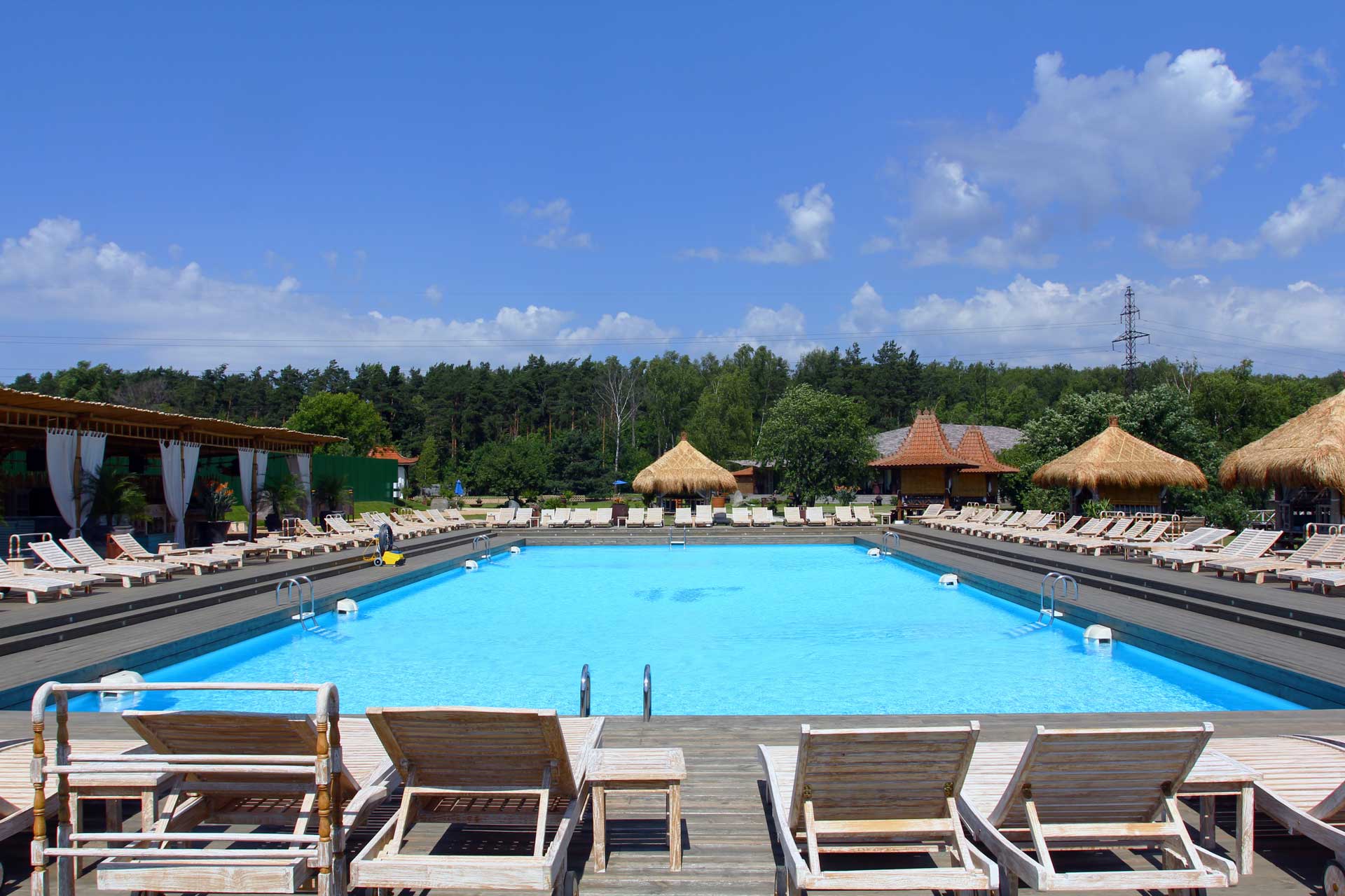 Piscina en Soho Beach con tarima de madera, amacas y vistas al bosque