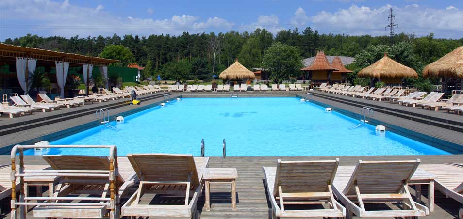 Piscina en Soho Beach con tarima de madera, amacas y vistas al bosque