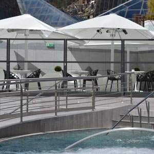 Terraza con cerramientos y parasol azores delante de piscina en Caldea