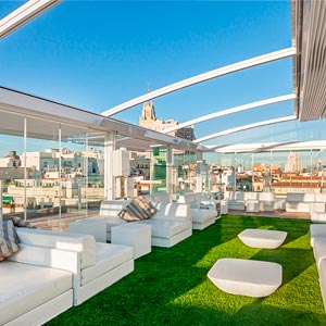 Pérgola abierta con sofás blancos en Hotel Oscar