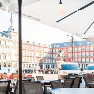 Vista a la plaza mayor de Madrid des de la terraza de un bar cubierto por un parasol Azores