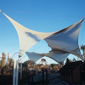 Estructura tensada al aire libre en parque temático Port Aventura con Dragon Khan de fondo