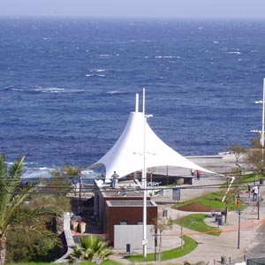 Vista aérea de estructura tensada en terraza de restaurante Porto moniz con mar de fondo