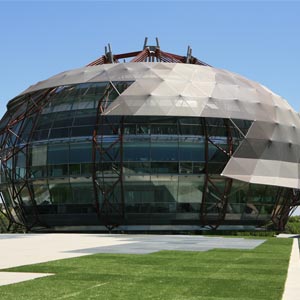 Lateral de la fachada textil en forma de óvalo de una infraestructura y equipamiento