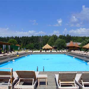 Piscina en Soho Beach con tarima de madera, amacas y vistas al bosque