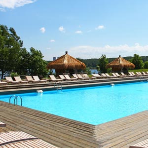 Piscina en Soho Beach con tarima de madera y amacas