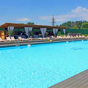 Piscina en Soho Beach con tarima de madera y amacas