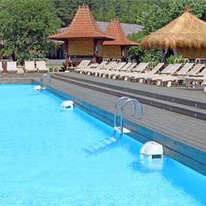 Piscina en Soho Beach con tarima de madera, amacas y vistas al bosque