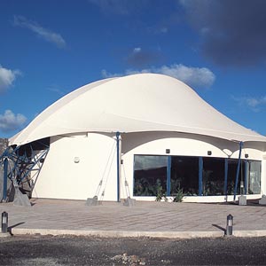 Estructura tensada semicircular cubriendo casetas en Sun garden aparthotel