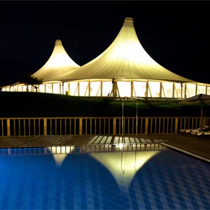 Estructura tensada en forma de carpa de circo de gran tamaño iluminada en jardín de cámping Zmar