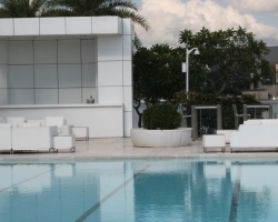 parasol oscuro con pie extremo en piscina