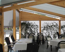 Pergola de madera con cerramientos laterales en restaurante