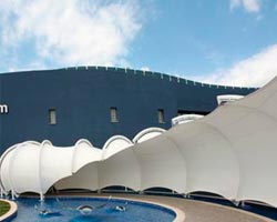 Estructura de lona en forma de gusano delante de piscina